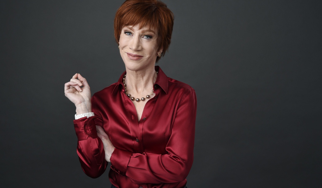 Рыжеволосая актриса Кэти Гриффин в красной рубашке на сером фоне