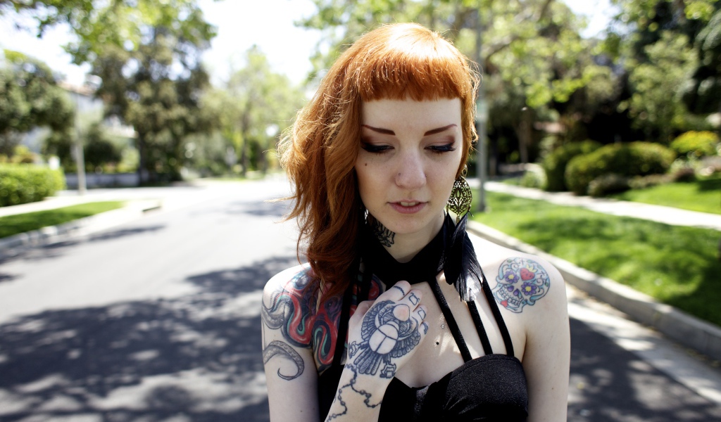 Рыжеволосая девушка неформалка с татуировками на теле