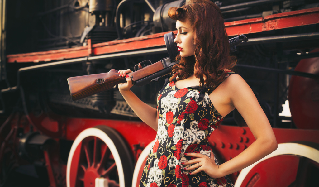 Retro girl with a gun in the hand of a diesel locomotive  