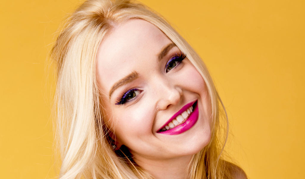 Улыбающаяся девушка актриса Дав Кэрон на желтом фоне крупным планом