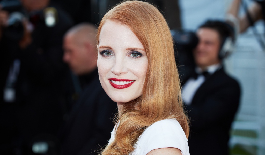 Улыбающаяся рыжеволосая девушка, актриса Джессика Честейн