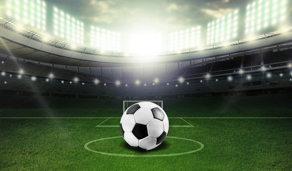 Футбольный мяч лежит на футбольном поле на стадионе