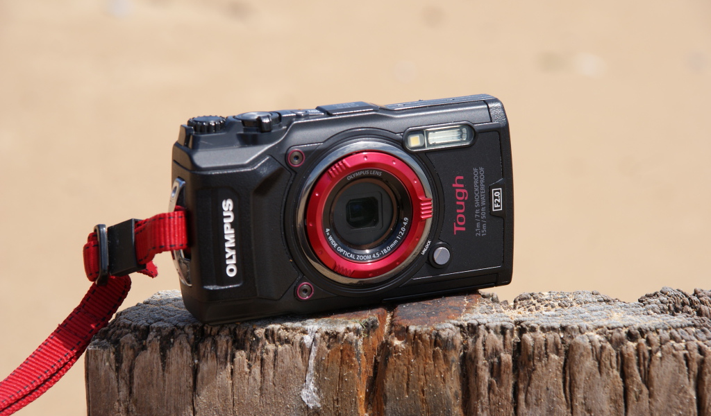 Стильный фотоаппарат Olympus Tough TG-5 стоит на пне