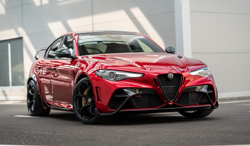 Красный автомобиль Alfa Romeo Giulia GTAm 2020 года у гаража