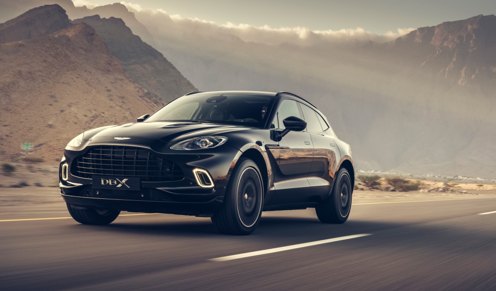 Черный автомобиль Aston Martin DBX 2020 года на трассе