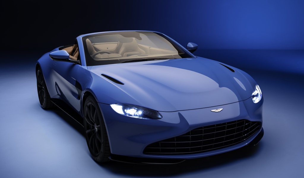 Кабриолет Aston Martin Vantage Roadster 2020 года на синем фоне