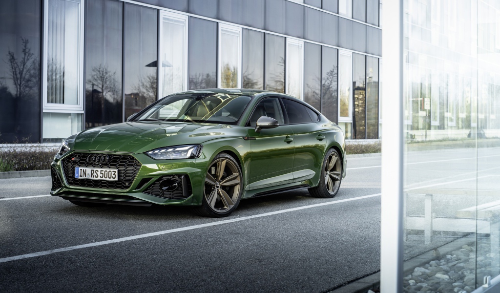 Зеленый автомобиль Audi RS 5 Sportback 2020 года у здания 