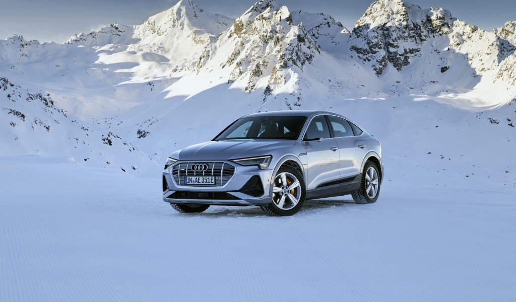 Автомобиль Audi E-Tron 55 Quattro Sportback S Line, 2020 года на фоне заснеженных гор 