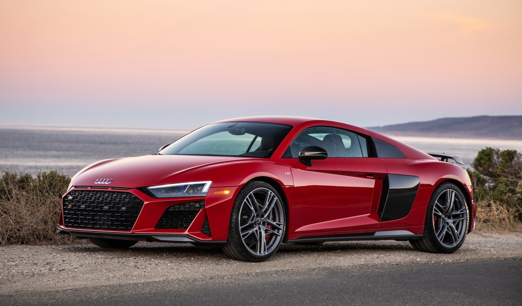 Красный спортивный автомобиль Audi R8 V10, 2020 года на фоне океана