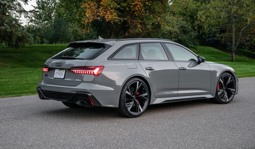 Серебристый автомобиль Audi RS 6 Avant, 2021 года вид сзади
