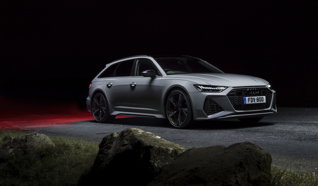 Серебристый автомобиль Audi RS 6 Avant 2020 года на дороге ночью 