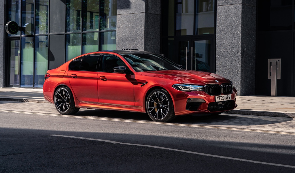 Красный автомобиль BMW M5 Competition 2020 года у дома