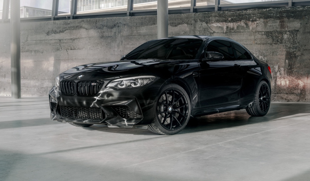 Черный автомобиль  BMW M2, 2020 года у бетонной стены