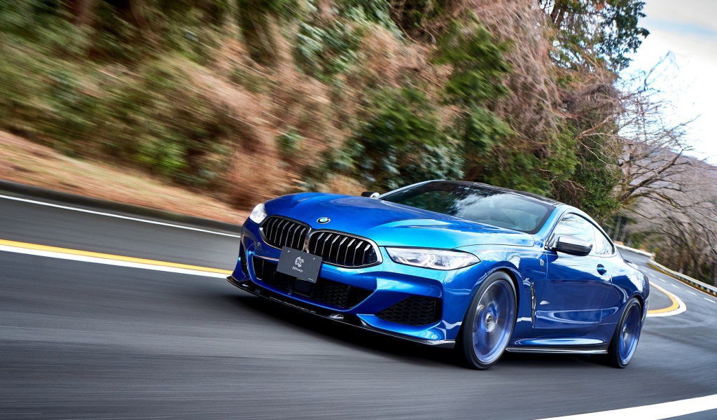 Синий автомобиль  BMW M850i XDrive Coupe 2020 года на дороге