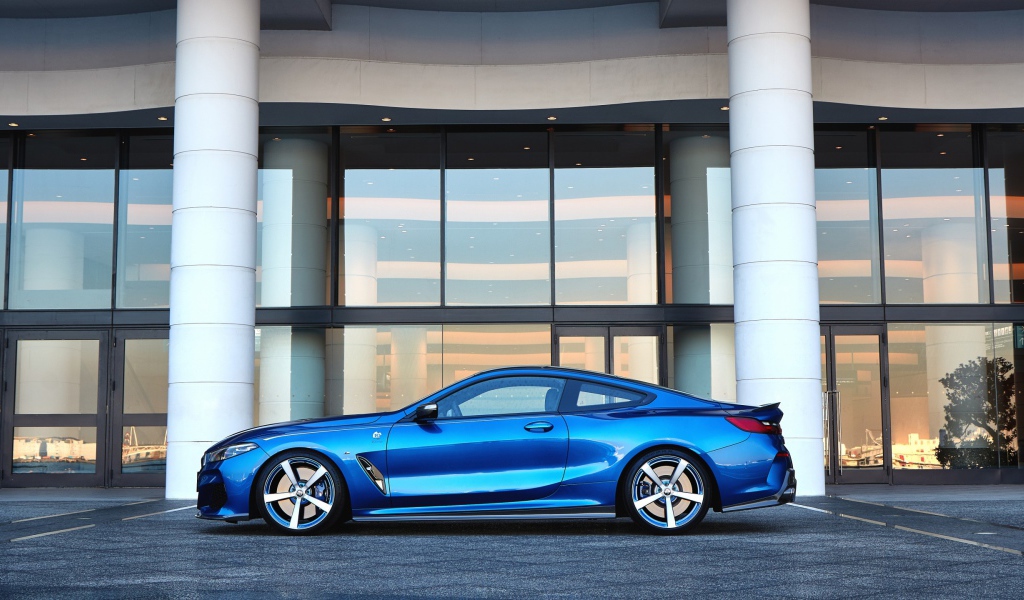Голубой автомобиль BMW M850i XDrive Coupe 2020 года у здания 
