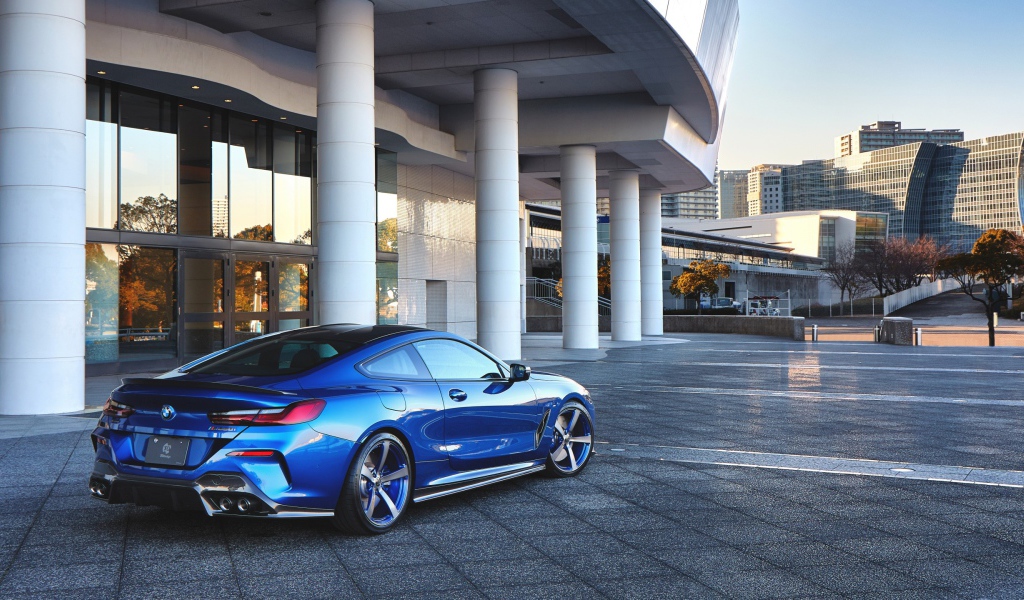 Синий автомобиль BMW M850i XDrive Coupe 2020 года у здания вид сзади