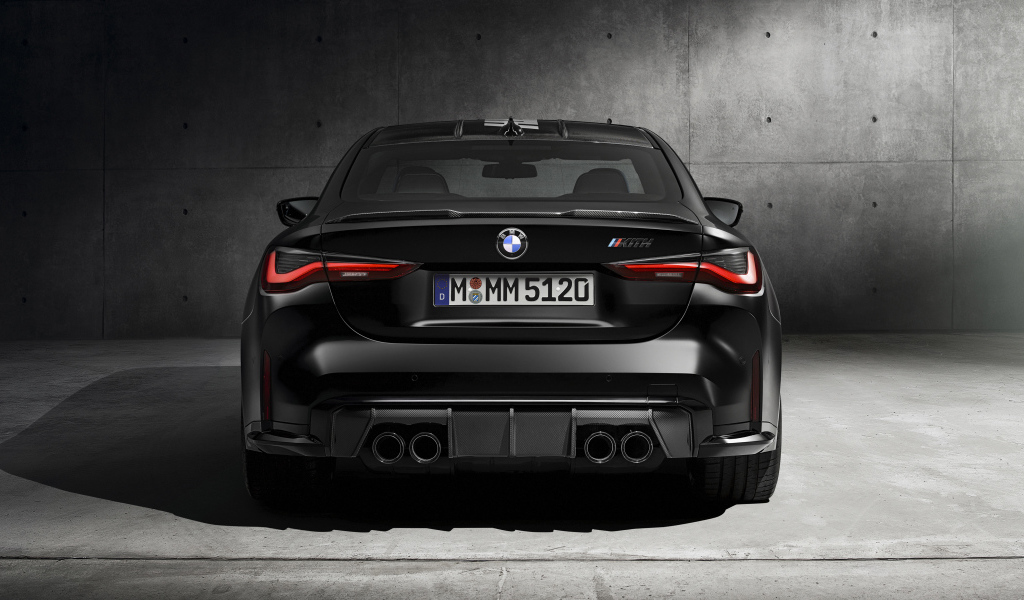 Черный BMW M4, 2021 года вид сзади на сером фоне