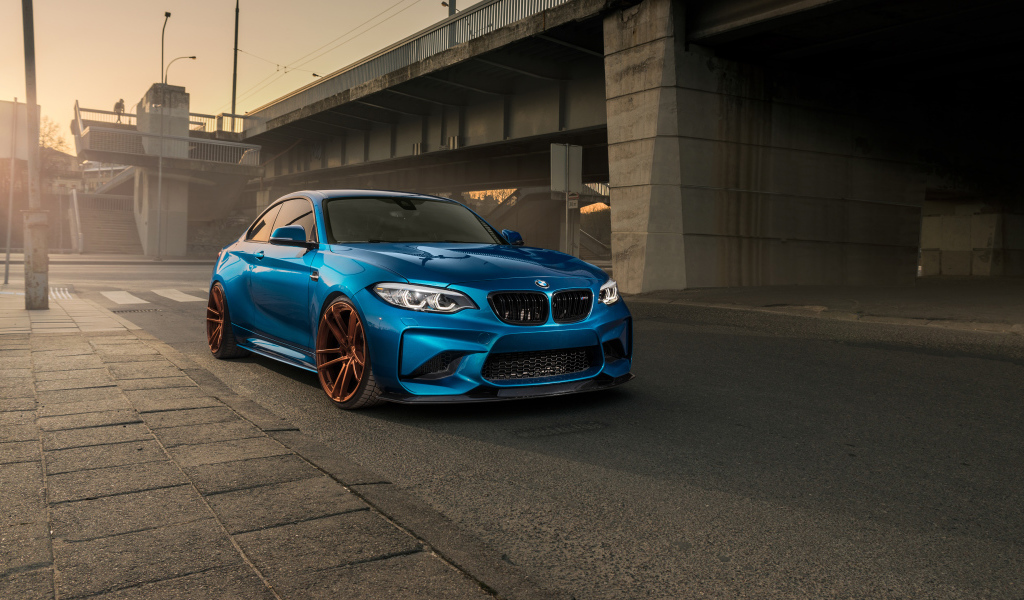 Синий автомобиль BMW M2 у моста 