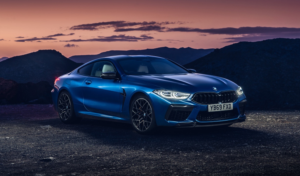 Синий автомобиль BMW M8, 2019 года на фоне гор