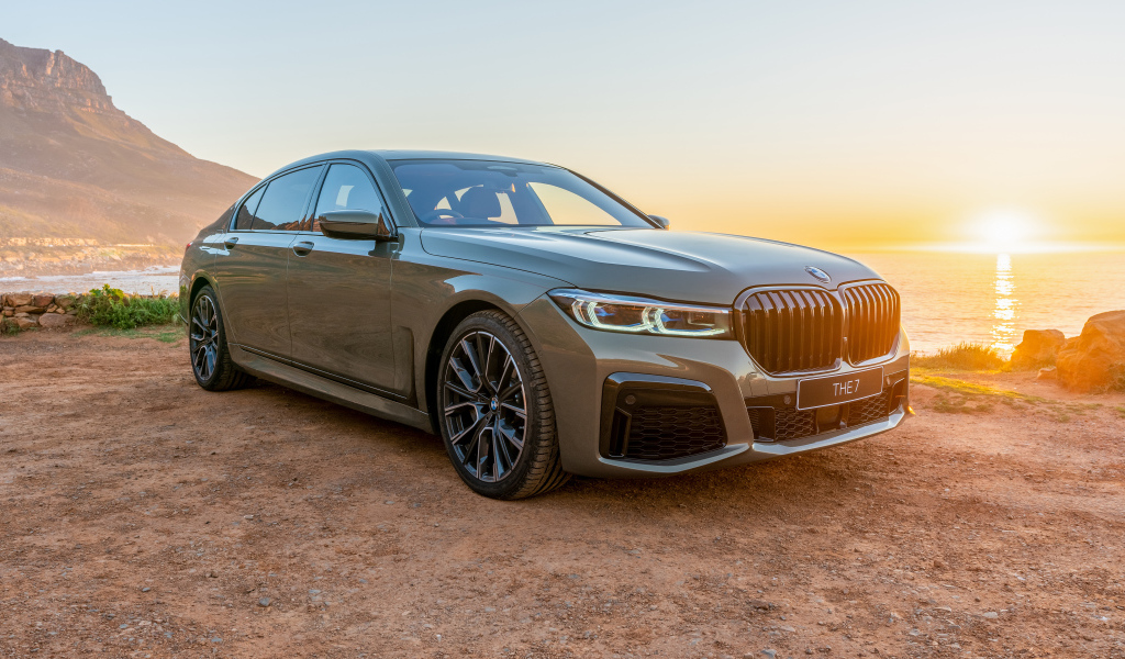 Стильный дорогой автомобиль BMW 745Le , 2020 года на фоне заката