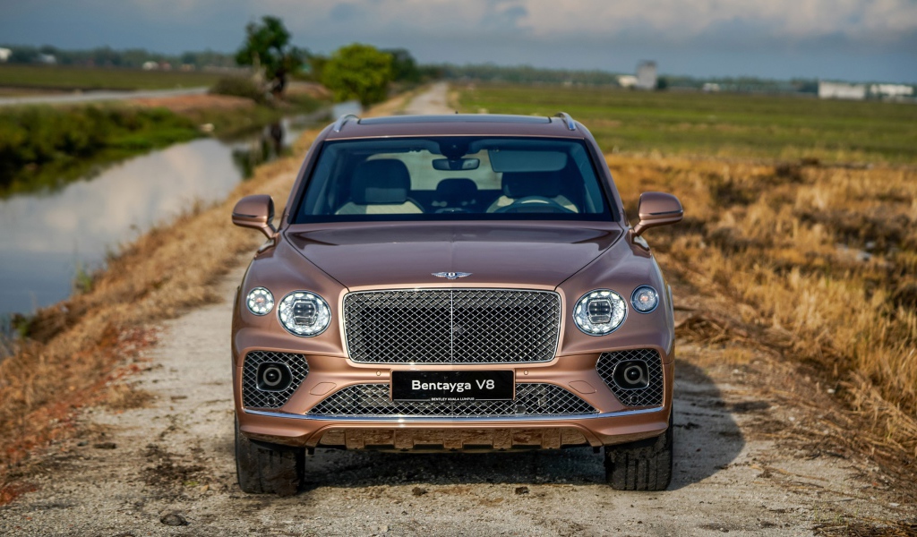 Коричневый автомобиль Bentley Bentayga V8 2020 года у реки