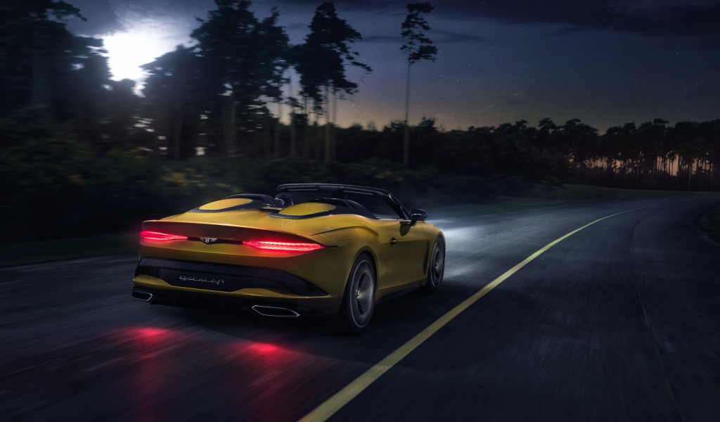 Желтый автомобиль Bentley Mulliner Bacalar 2020 года на ночной трассе 