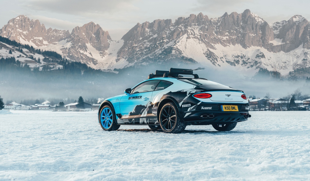 Автомобиль bentley continental gt, 2020 года на фоне заснеженных гор 