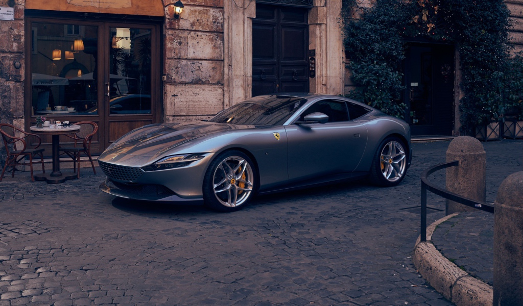Серебристый автомобиль Ferrari Roma 2020 года у кафе