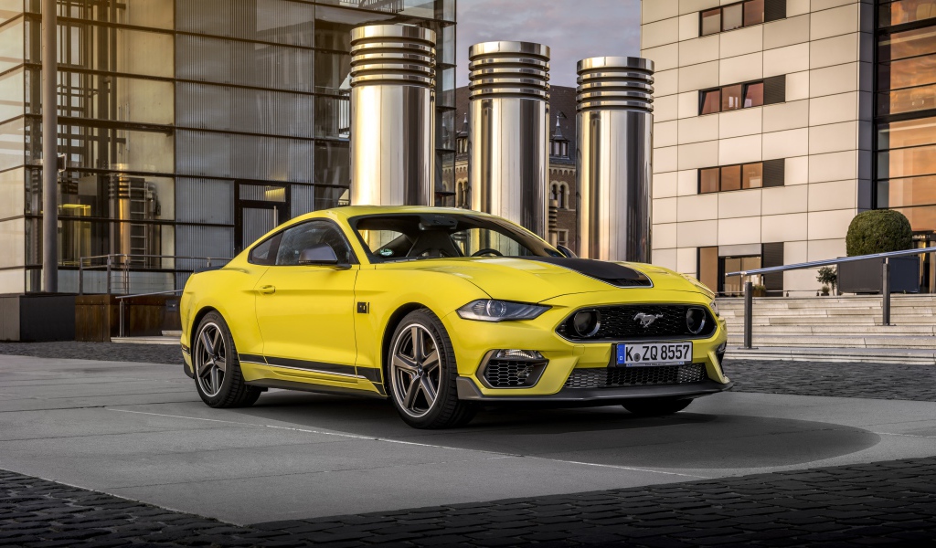 Быстрый желтый автомобиль Ford Mustang Mach 1 2021 года у здания 