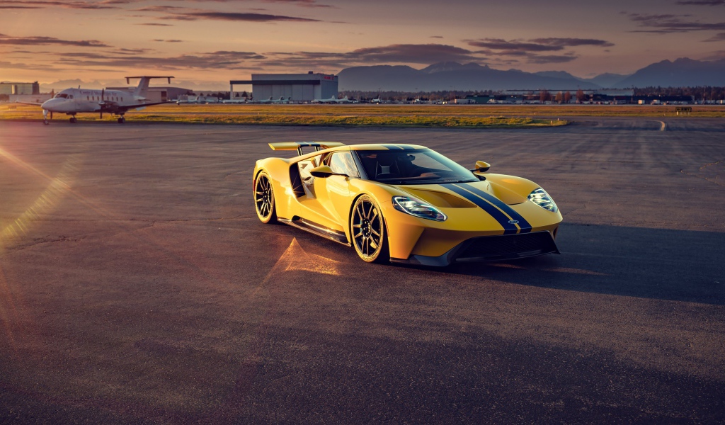 Желтый гоночный автомобиль Ford GT на взлетной полосе 