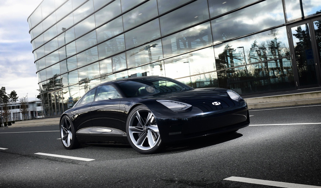 Черный автомобиль Hyundai Prophecy 2020 года у стеклянного здания 