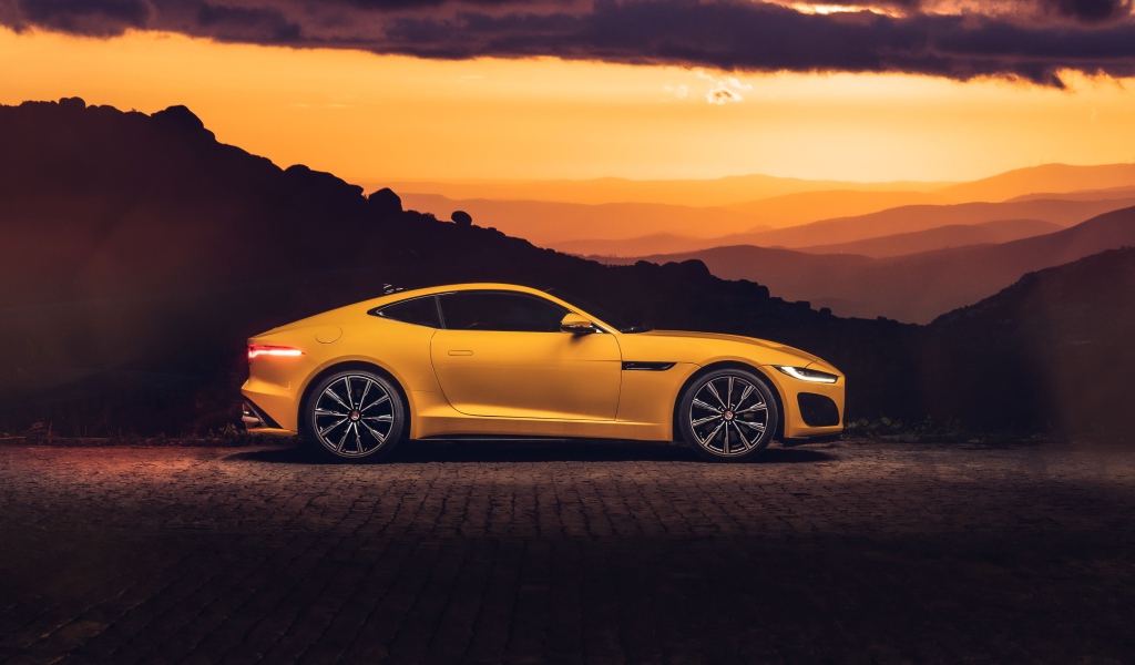 Желтый автомобиль jaguar f type 2020 года на закате 