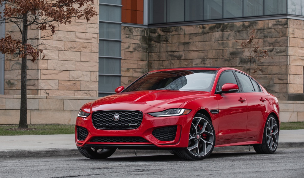 Красный автомобиль Jaguar XE P300 R-Dynamic, 2020 года у здания
