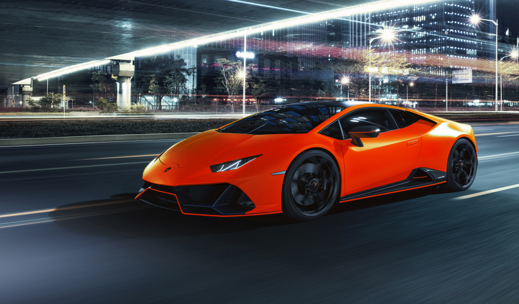 Оранжевый автомобиль Lamborghini Huracán EVO 2021 года на фоне города