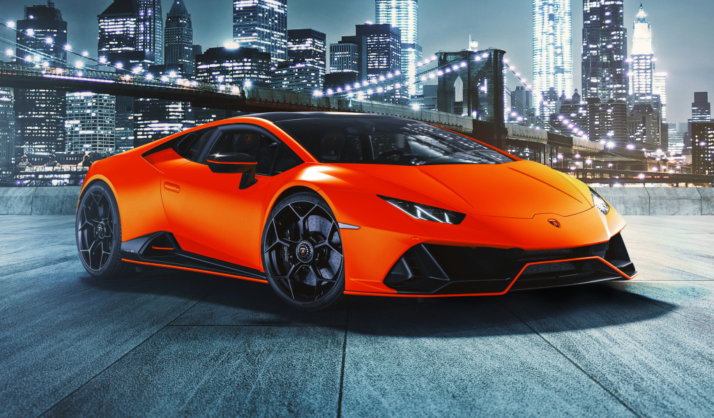 Оранжевый автомобиль Lamborghini Huracán EVO 2021 года на фоне небоскребов