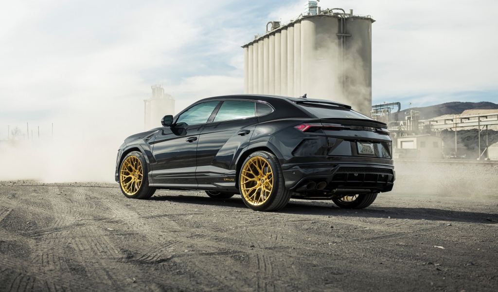 Черный внедорожник  Lamborghini Urus 2020 года на фоне завода вид сзади