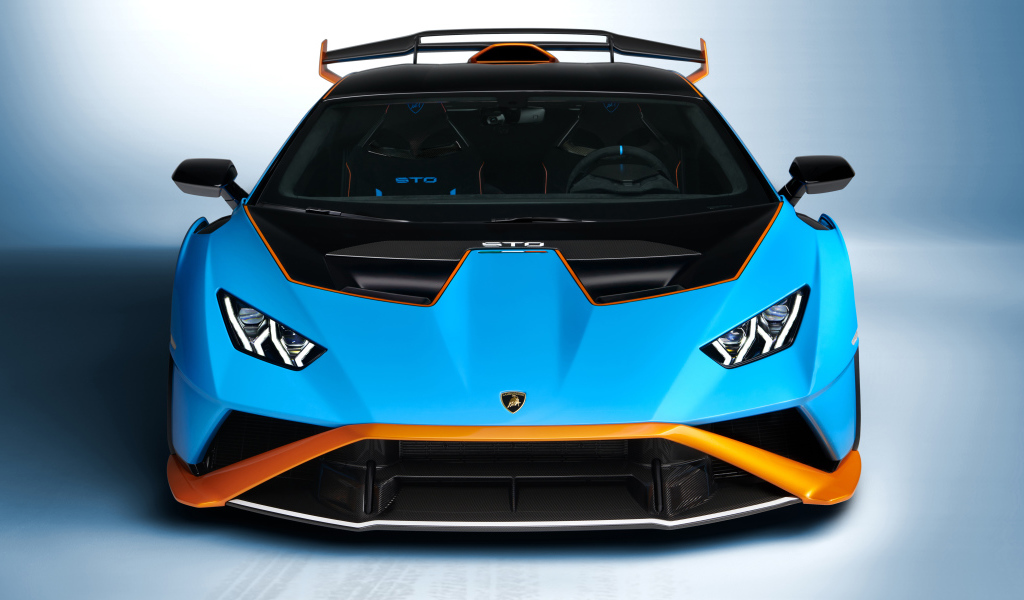 Голубой автомобиль Lamborghini Huracán STO 2021 года вид спереди на сером фоне
