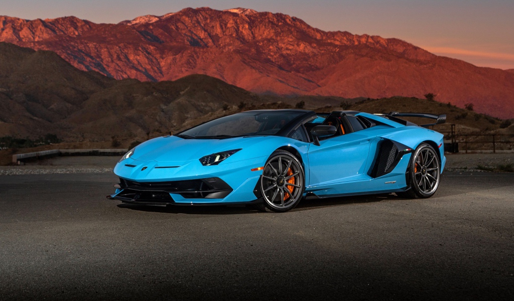 Голубой спортивный автомобиль Lamborghini Aventador SVJ Roadster, 2020 года на фоне гор
