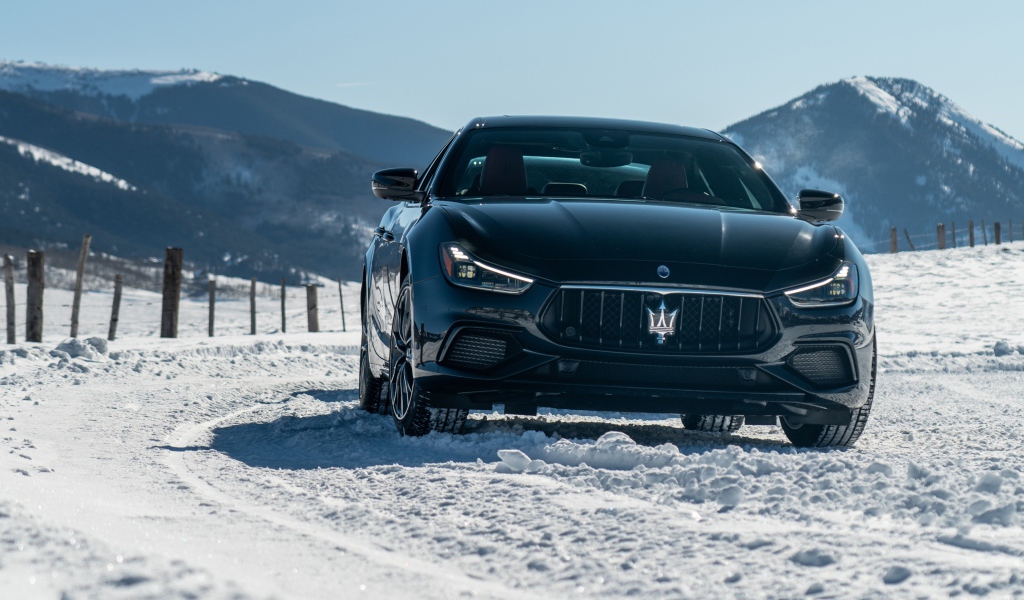 Черный автомобиль Maserati Ghibli S Q4, 2020 года едет по заснеженной дороге