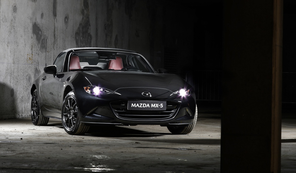 Черный автомобиль Mazda MX-5 Eunos Edition 2020 года с включенными фарами