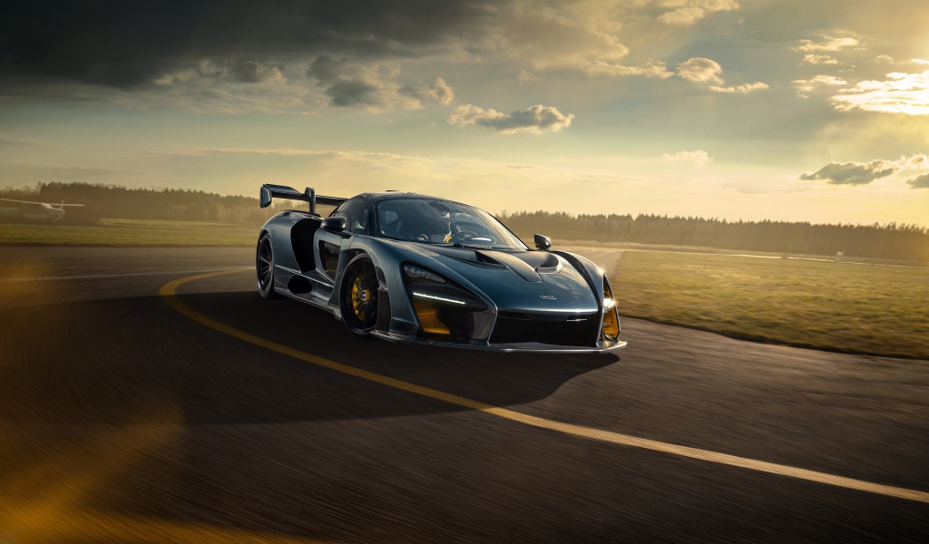 Гоночный автомобиль  McLaren Senna 2020 года на фоне заката 