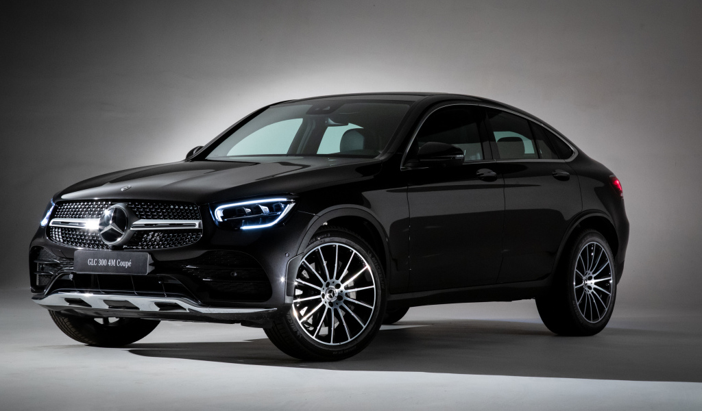 Черный стильный автомобиль Mercedes-Benz GLC 300,  2019 года на сером фоне