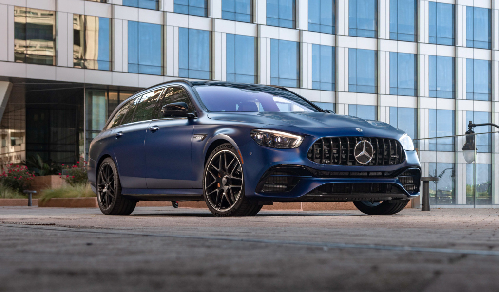 Синий автомобиль Mercedes-AMG E 63 S 4MATIC+, 2021 года на фоне дома