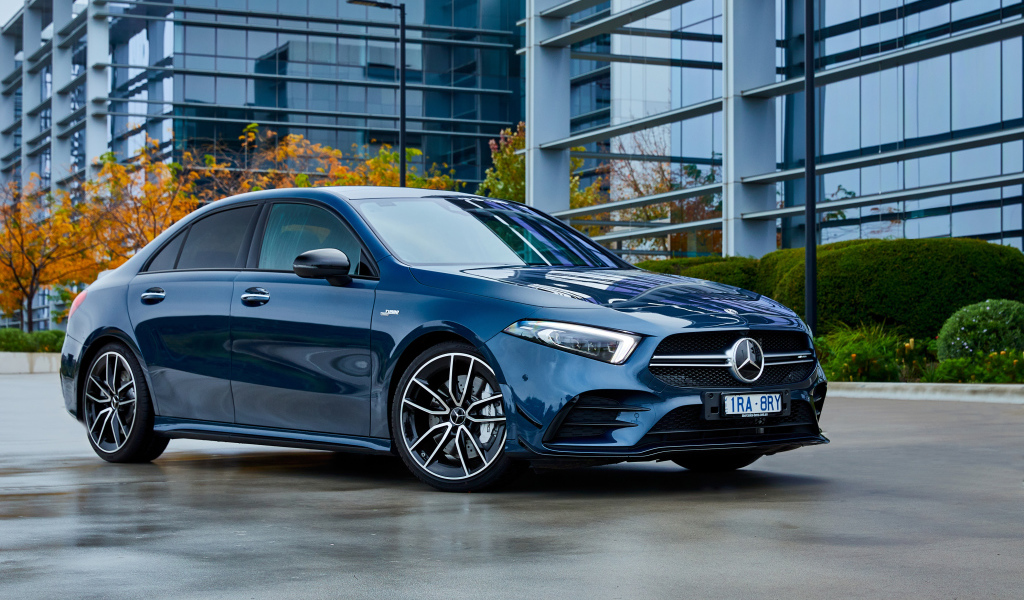 Синий автомобиль Mercedes-Benz AMG A 35, 2020 года на фоне здания 