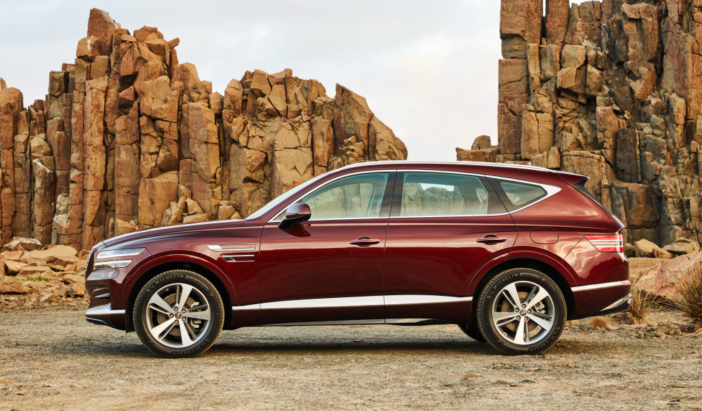 Бордовый автомобиль Genesis GV80 2.5T 2020 года на фоне гор