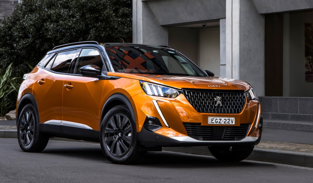 Оранжевый внедорожник Peugeot 2008 GT 2020 года у дома 
