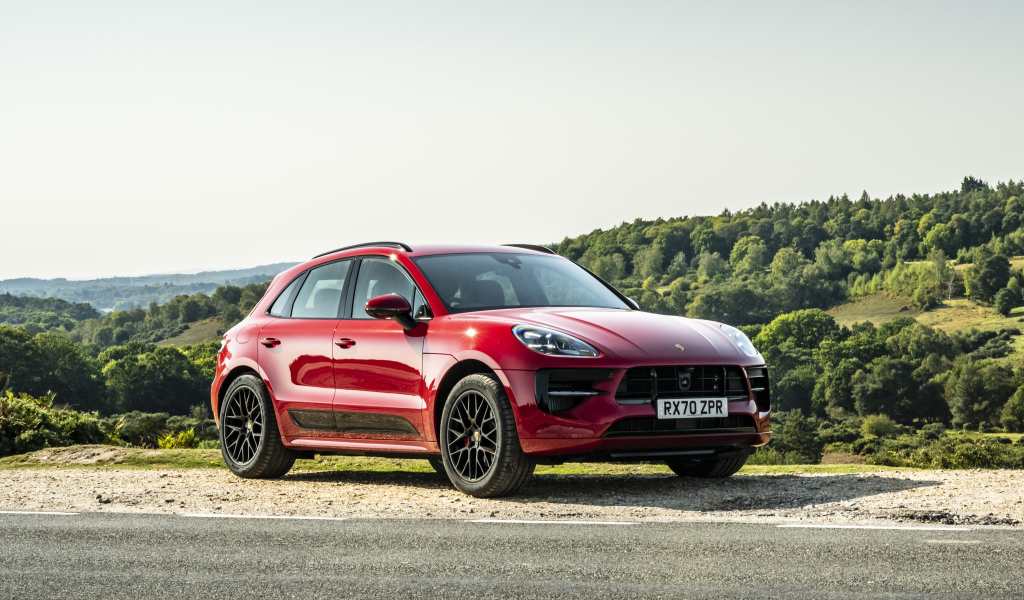 Красный автомобиль Porsche Macan GTS 2020  года в лучах солнца