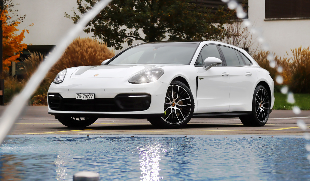 Белый автомобиль Porsche Panamera 4S E-Hybrid Sport Turismo 2020 года у бассейна