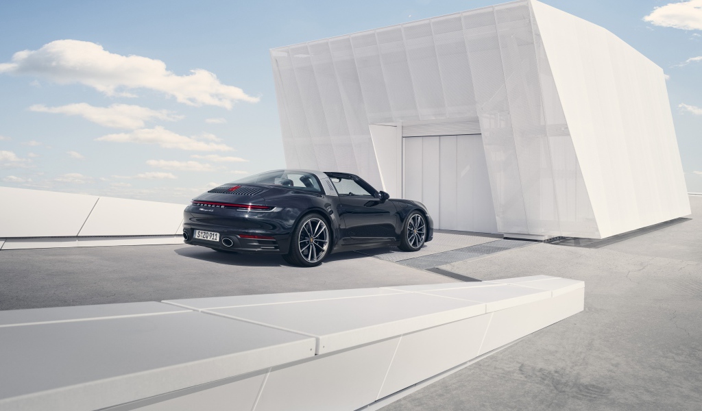 Черный автомобиль Porsche 911 Targa 4S 2020 года у гаража 