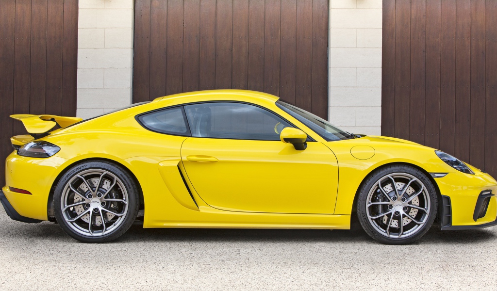 Желтый автомобиль Porsche 718 Cayman GT4 2020 года вид сбоку
